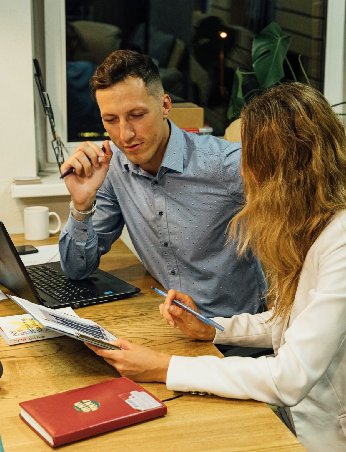 Two professionals having a discussion at a desk