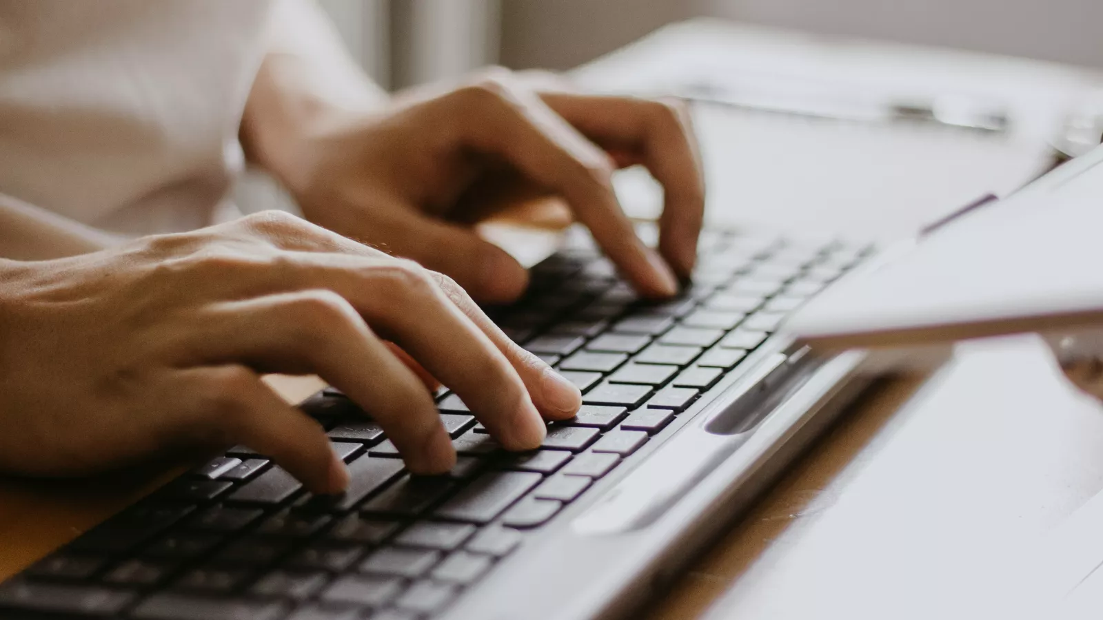 Hands type on a computer key board