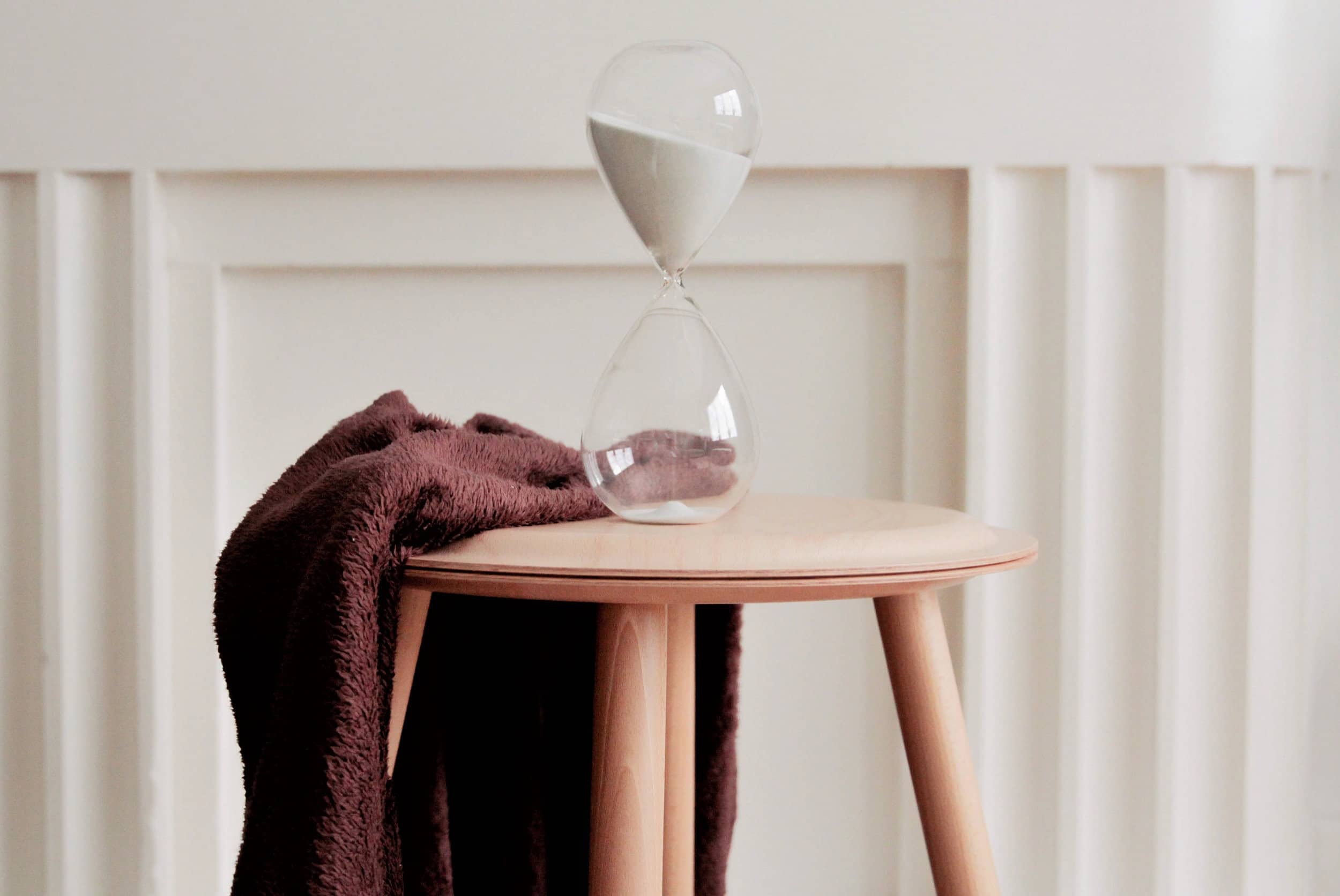 An hourglass with sand running out of the top section