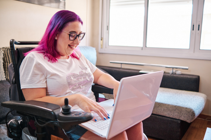 A woman in wheelchair using laptop computer.