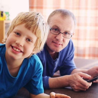 Smiling child with father using tablet device
