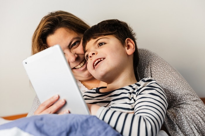 Mother and son smiling looking at a tablet