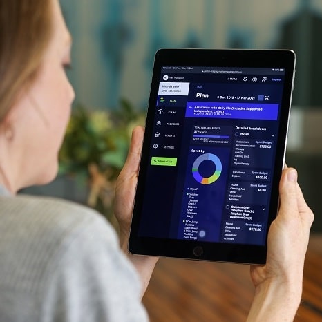 Woman holding tablet with MPM Client portal displayed