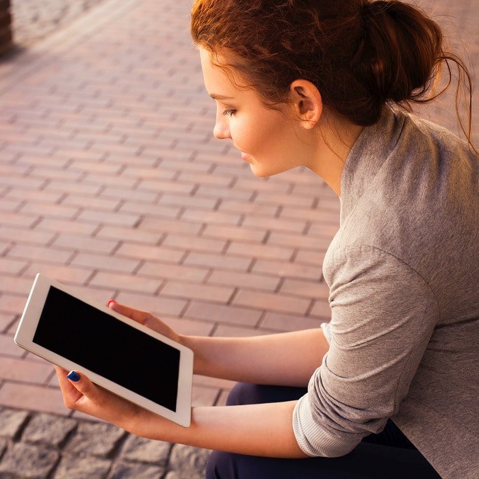 Woman sitting looking at a tablet Woman sitting looking at a tablet