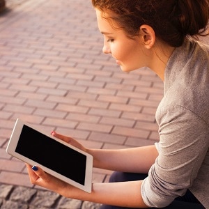 A woman sitting looking at a tablet