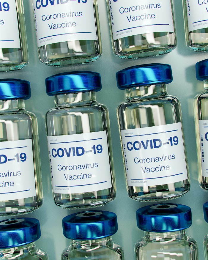 Several vials with labels reading 'COVID-19 Coronavirus vaccine'.