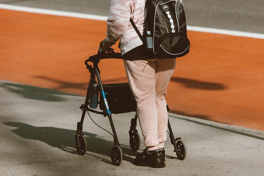 A photo of a person on a footpath using a walking device