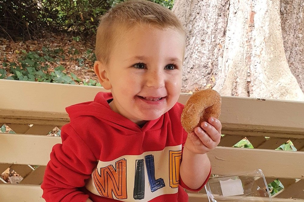 Paige's 3-year-old son Oak holding a donut