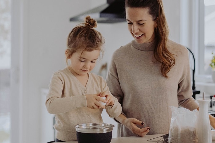 A parent and daughter baking in the kitchen