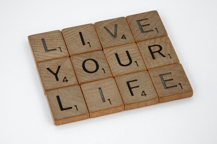 Scrabble tiles spell out 'live your life.'