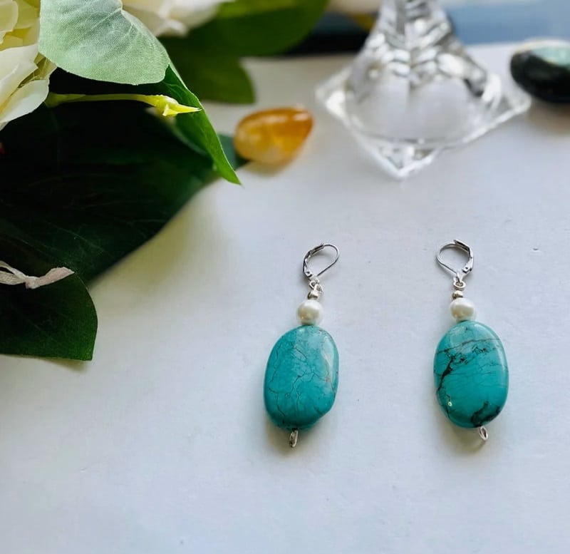A pair of turquoise and pearl drop earrings.
