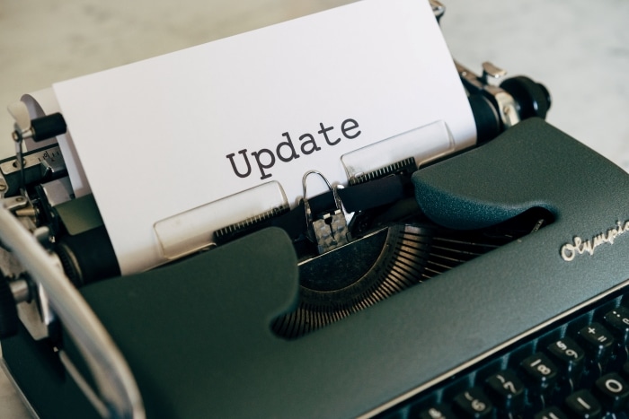 A piece of white paper with the word 'update' sits in a black typewriter.