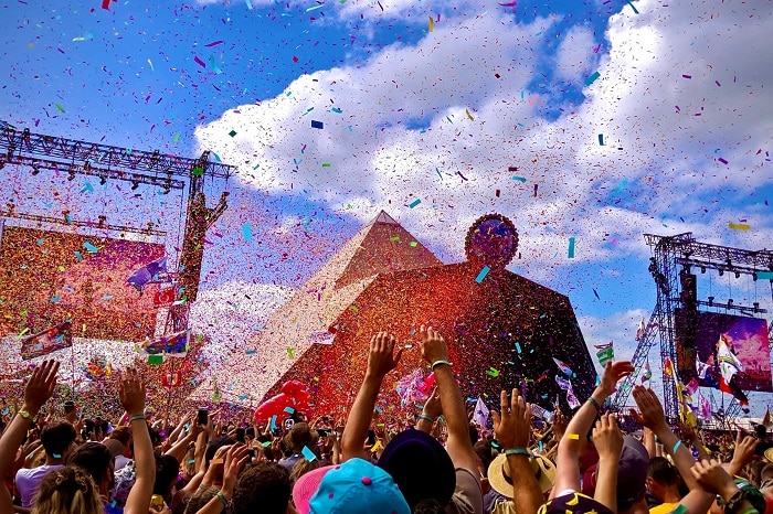 People partying at a festival, with confetti flying through the air.