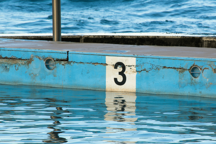 The number three painted on the side of a pool.
