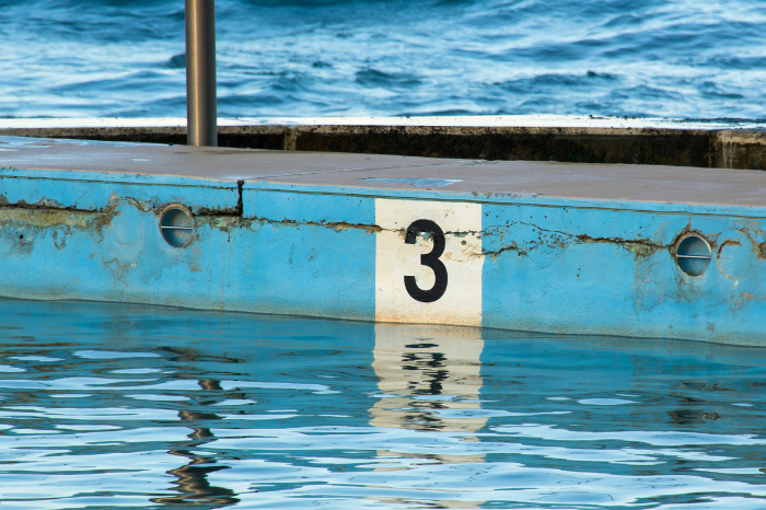 The number three painted on the side of a pool.