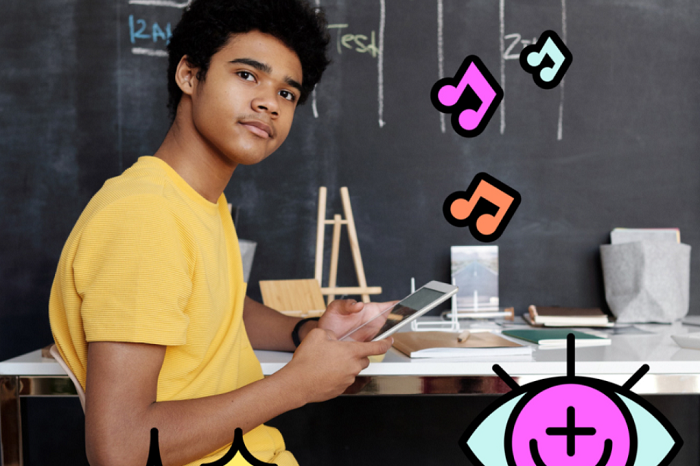 A teenage boy sits at a desk holding a tablet. Colourful musical graphics are also pictured.