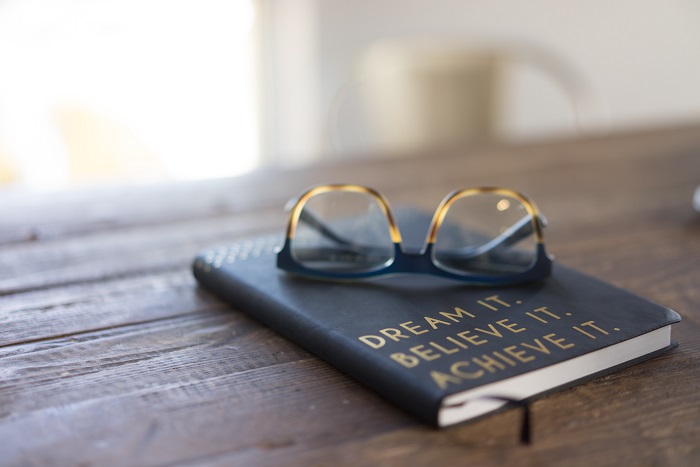 A notebook with reading glasses.