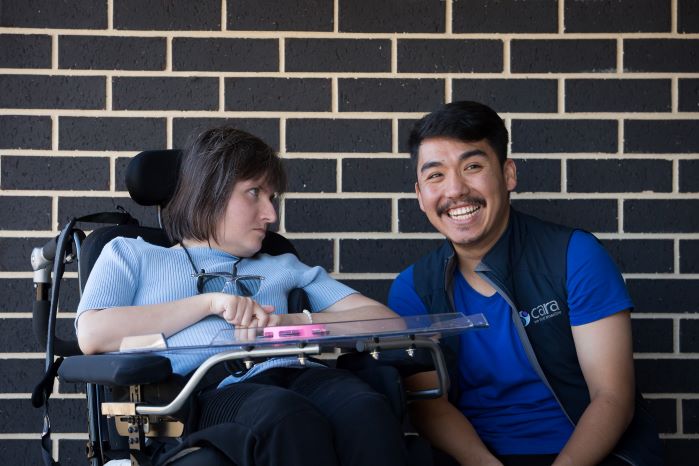 A person with disability meets with their smiling support worker.