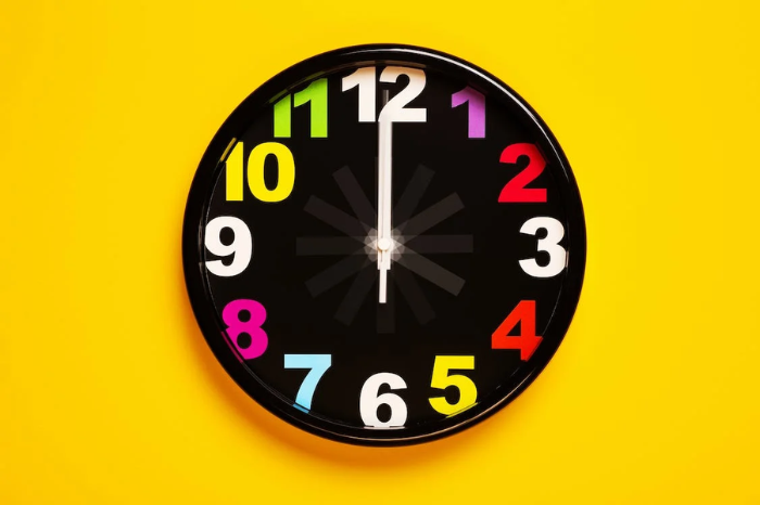 A black clock on a bright yellow background.