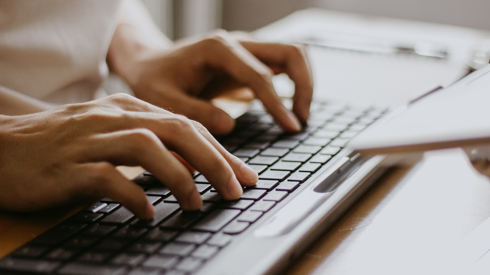 Hands type on a computer key board.