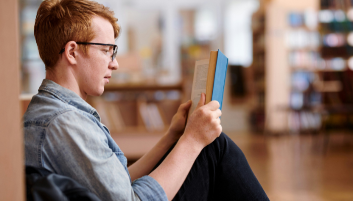 A side-view of a person with an open book.