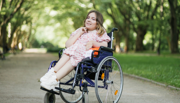 A person in a wheelchair on a tree-lined street.