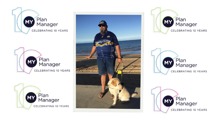 A picture of Alan in front of a beach with his Seeing Eye Dog Xenon, against a My Plan Manager 10th anniversary-themed backdrop.